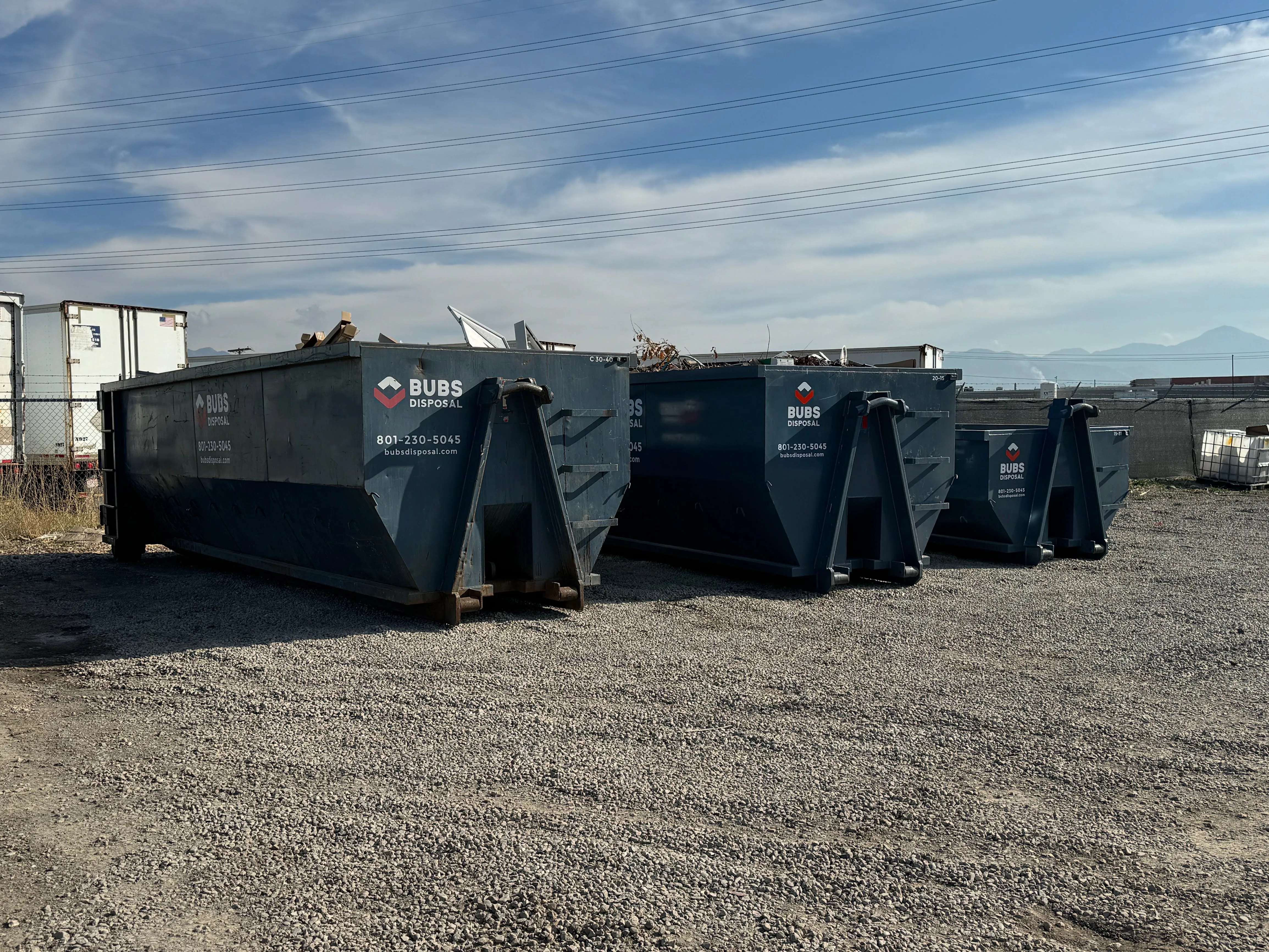 Bubs Disposal dumpster fleet with three sizes lined up against the Wasatch mountains